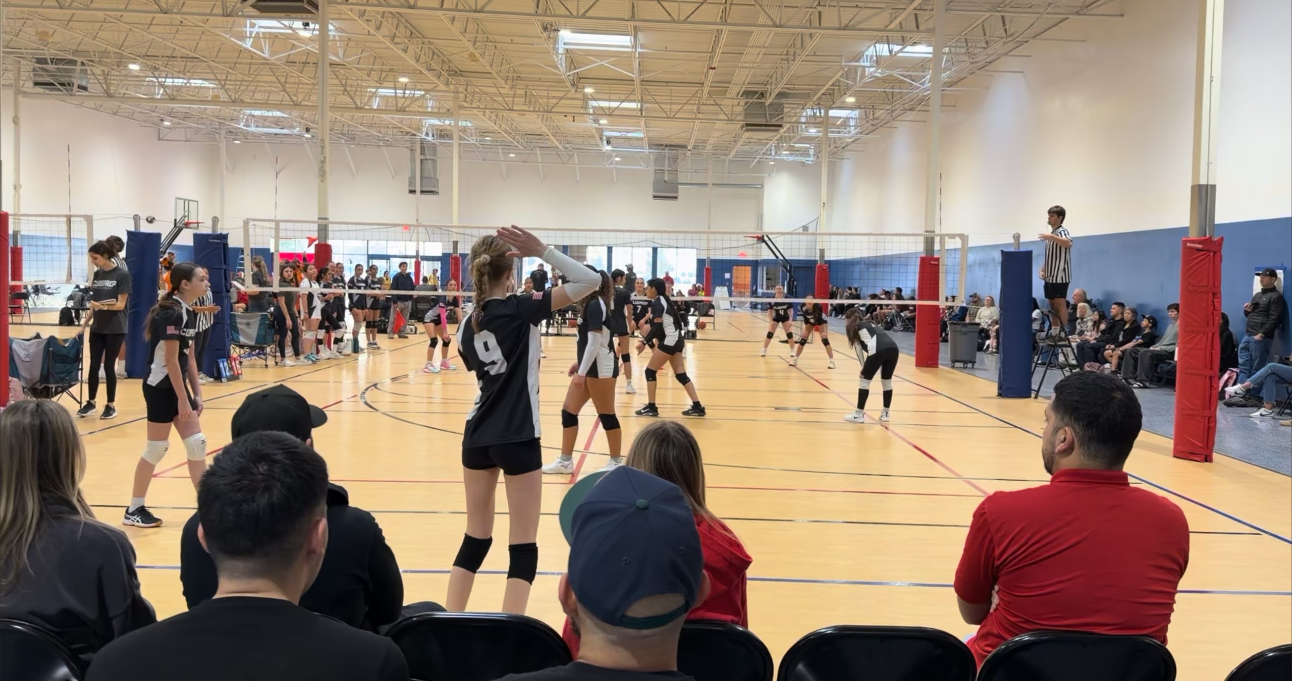 Players competing in a volleyball game on the indoor courts at Blitz Sports Center